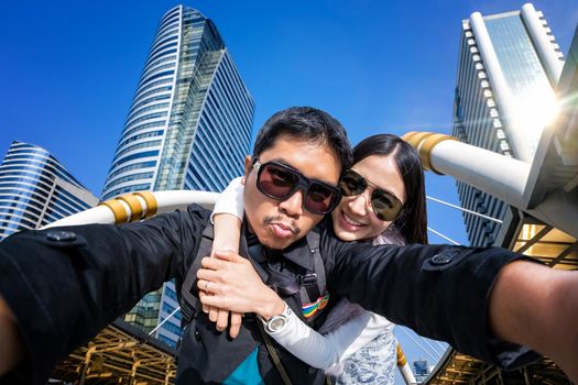 Young Couple Tourists selfie with mobile phone in a sky walk in Sathorn Thailand 