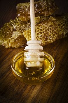 Yellow Honey and Honeycomb slice on a wooden table