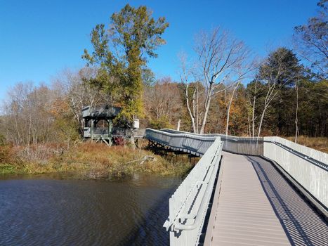 boardwalk path or trail with fence and wood tower or lookout with water