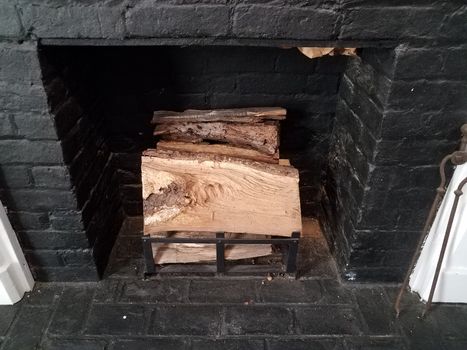 black brick or masonry fireplace with chopped firewood logs