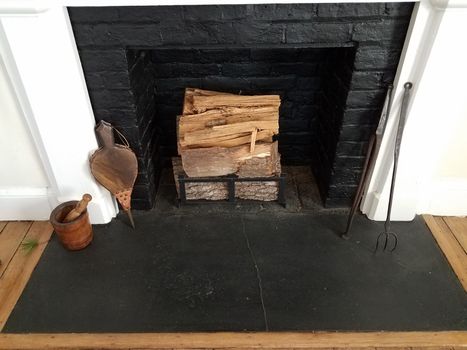 black brick or masonry fireplace with chopped firewood logs