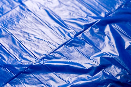 crumpled polyethilene film abstract background with selective focus.