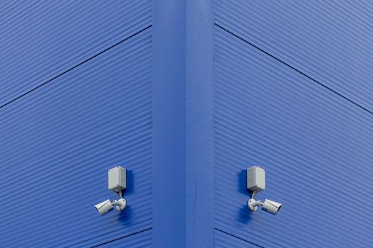 two small white security cameras on blue steel building corner.