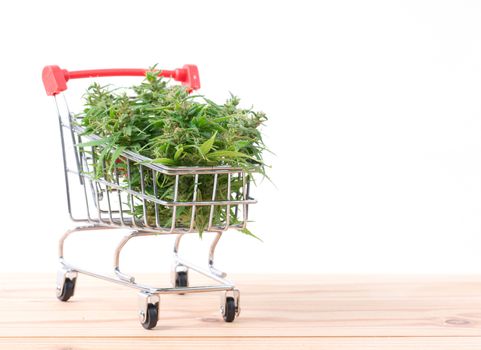 fresh marijuana flower in shopping cart on table