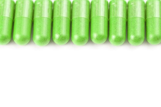 row of ufo green color organic capsules isolated on white background closeup with selective focus.
