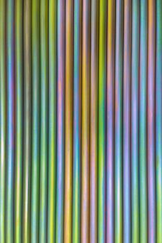 An abstract lines backround of colorful cadmium coated steel bars. Industrial grade chemical protective coating for metal parts.