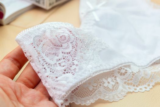 Lace on white womens bikini panties close-up. Soft texture of the fabric of women's underwear