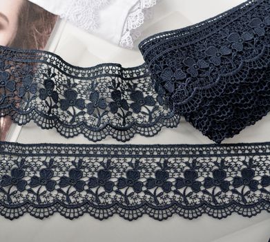 Tapes of blue gentle guipure, beauty silk lace fabric on light background. Elastic material. Using for Atelier and needlework store. Flat lay style