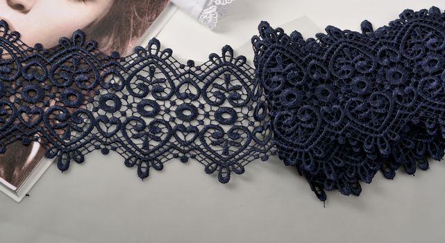 Tapes of blue gentle guipure, beauty silk lace fabric on light background. Elastic material. Using for Atelier and needlework store. Flat lay style