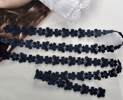 Tapes of blue gentle guipure, beauty silk lace fabric on light background. Elastic material. Using for Atelier and needlework store. Flat lay style