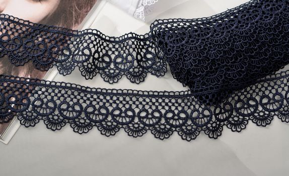 Tapes of blue gentle guipure, beauty silk lace fabric on light background. Elastic material. Using for Atelier and needlework store. Flat lay style
