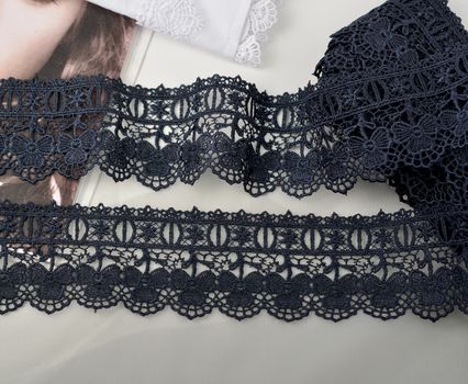 Tapes of blue gentle guipure, beauty silk lace fabric on light background. Elastic material. Using for Atelier and needlework store. Flat lay style