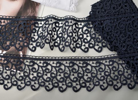 Tapes of blue gentle guipure, beauty silk lace fabric on light background. Elastic material. Using for Atelier and needlework store. Flat lay style