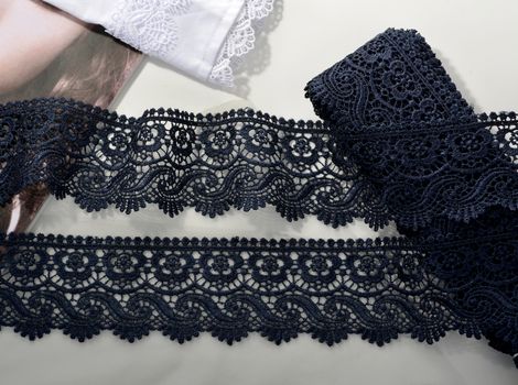 Tapes of blue gentle guipure, beauty silk lace fabric on light background. Elastic material. Using for Atelier and needlework store. Flat lay style
