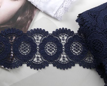 Tapes of blue gentle guipure, beauty silk lace fabric on light background. Elastic material. Using for Atelier and needlework store. Flat lay style