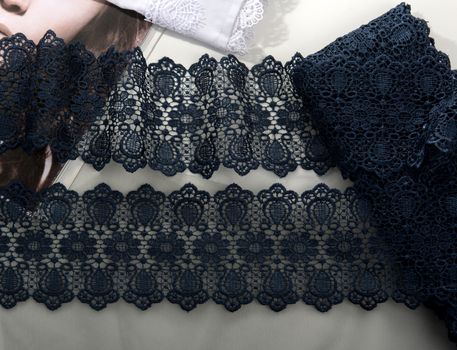 Tapes of blue gentle guipure, beauty silk lace fabric on light background. Elastic material. Using for Atelier and needlework store. Flat lay style