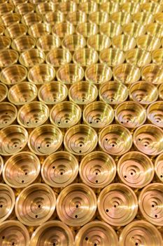 an abstract perspective industrial close-up background of shiny brass metal threaded hexagonal fitting parts.