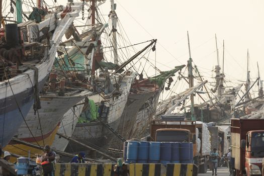 Jakarta, Sunda Kelapa Port, Indonesia - July 15, 2019: Boats, goods and workers in the port of the city of Jakarta, on the shores of Jakarta Bay.