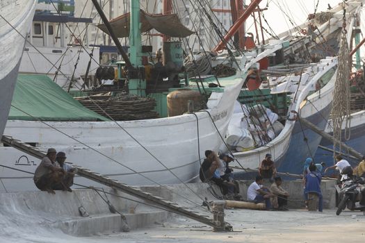 Jakarta, Sunda Kelapa Port, Indonesia - July 15, 2019: Boats, goods and workers in the port of the city of Jakarta, on the shores of Jakarta Bay.