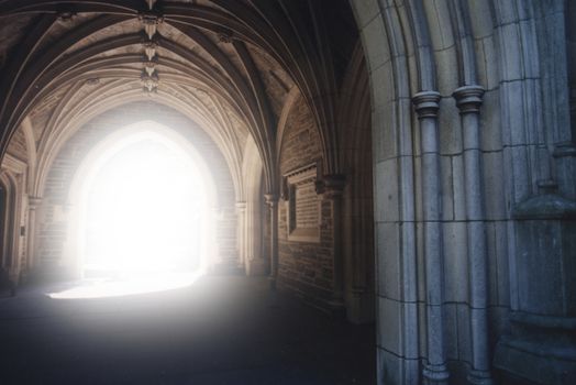 Gothic archway with light illuminating the path.