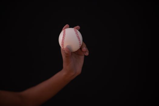 Person holding baseball in hand