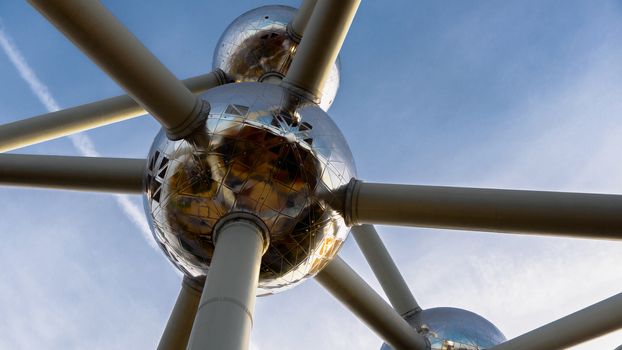 Atom model against blue sky made of steel