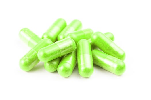 pile of ufo green organic capsules isolated on white background closeup with selective focus.