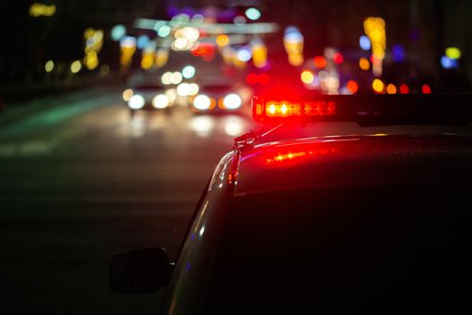police car lights at night in city with selective focus and bokeh.