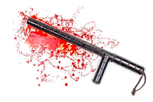 Bloody russian police rubber tonfa baton in blood spatter isolated on white background in top-down flat lay perspective. Natural human blood used.