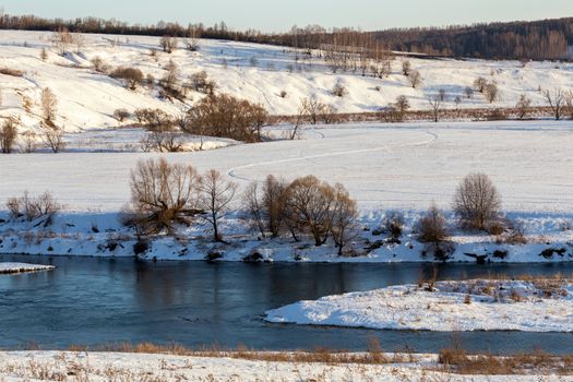 winter russian riverside wiew under direct evening sunlight.