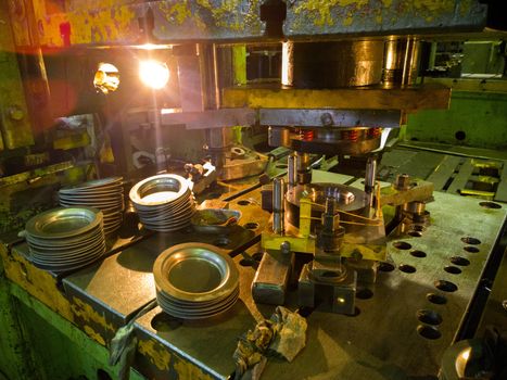 Dirty used low tech stamping press producing round aliminium parts. Selective focus technicque.