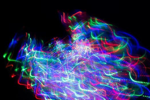 Abstract light paint pattern in dark room forming a wave.