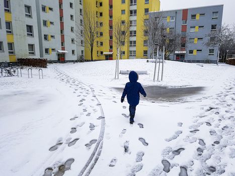 Child runs through the snow in Leherheide, Bremerhaven in Germany.