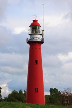 Photo of a Red lighthouse standing on the hill