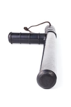 Black classic rubber police tonfa baton isolated on white background with selective focus and wide angle perspective.