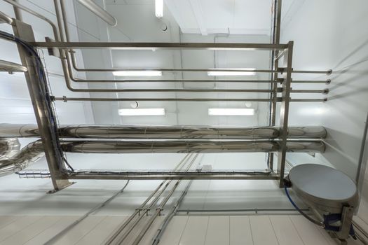 Industrial shiny steel pipeline overhead ceiling upward background. Chemical laboratory and science room style.