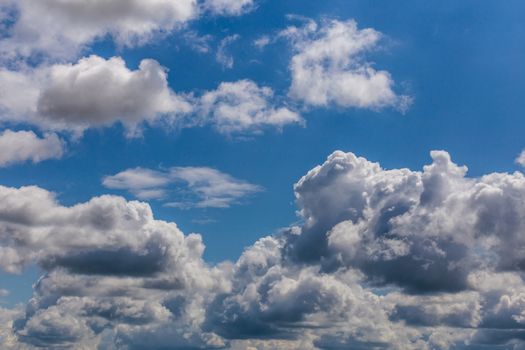 Regular summer clouds on blue sky at daylight in continental europe. Close shot wit telephoto lens