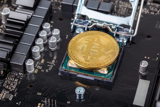 cryptocurrency background - bitcoin physical shiner in cpu socket of modern cpu motherboard with selective focu and blur