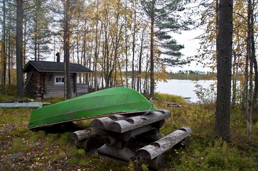 A cabin and boat at a lake in the region of Kainuu, Finland