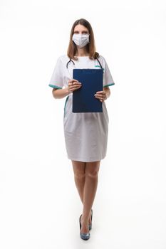 girl doctor in medical clothes and mask with tablet in hand on white background
