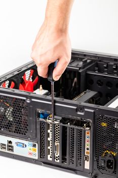 right caucasian engineer's unscrewing a video card bracket with screwdriver while maintenance personal computer hardware with selective focus closeup