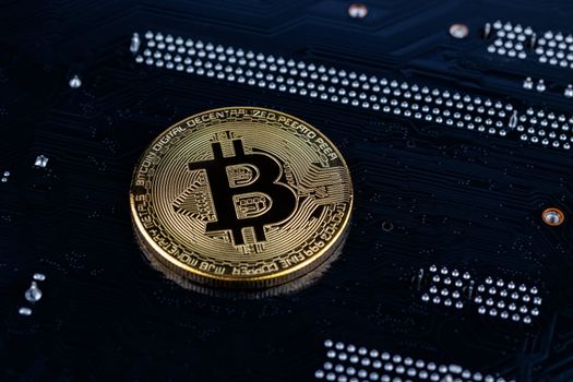 cryptocurrency background - bitcoin physical shiner ion black electronic board with selective focus and blur