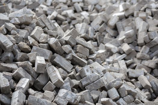 Pile of dismounted gray modern urban pavement bricks with selective focus. Result of russian government corruption in city infrastructure renovation.