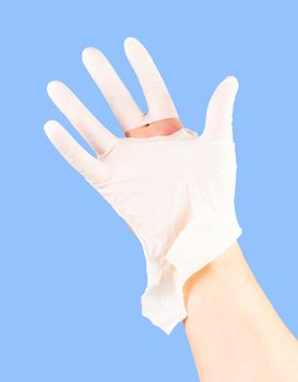 broken white latex surgeon medical glove on caucasian hand isolated on blue monocolor background.