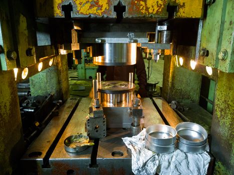 Dirty used low tech stamping press producing round aliminium parts. Selective focus technicque.