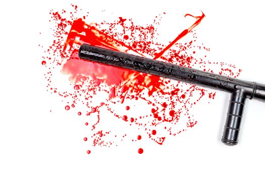 Bloody russian police rubber tonfa baton in blood spatter isolated on white background in top-down flat lay perspective. Natural human blood used.