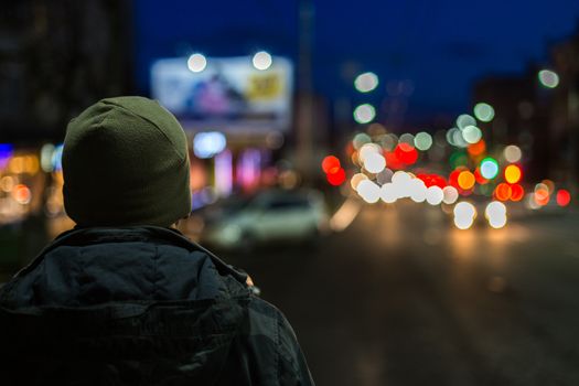 stranger man back in night city with boke background at cold season