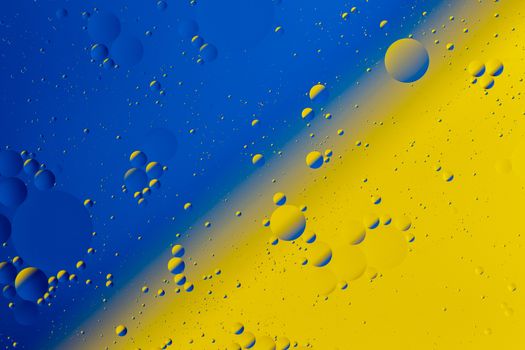 Oil on water flat colorful duotone macro abstract background photographic image. Blue-yellow Ukrainian national theme.