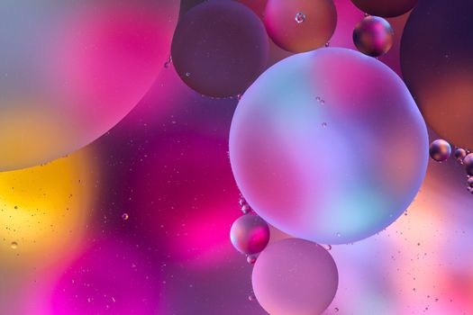 pastel pink and purple surface with abstract round shapes structure of oil in water.