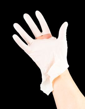 broken white latex surgeon medical glove on caucasian hand isolated on black background.